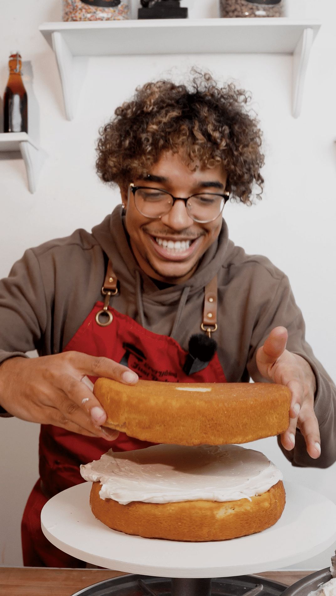 Baker placing the top layer onto buttercream filling.